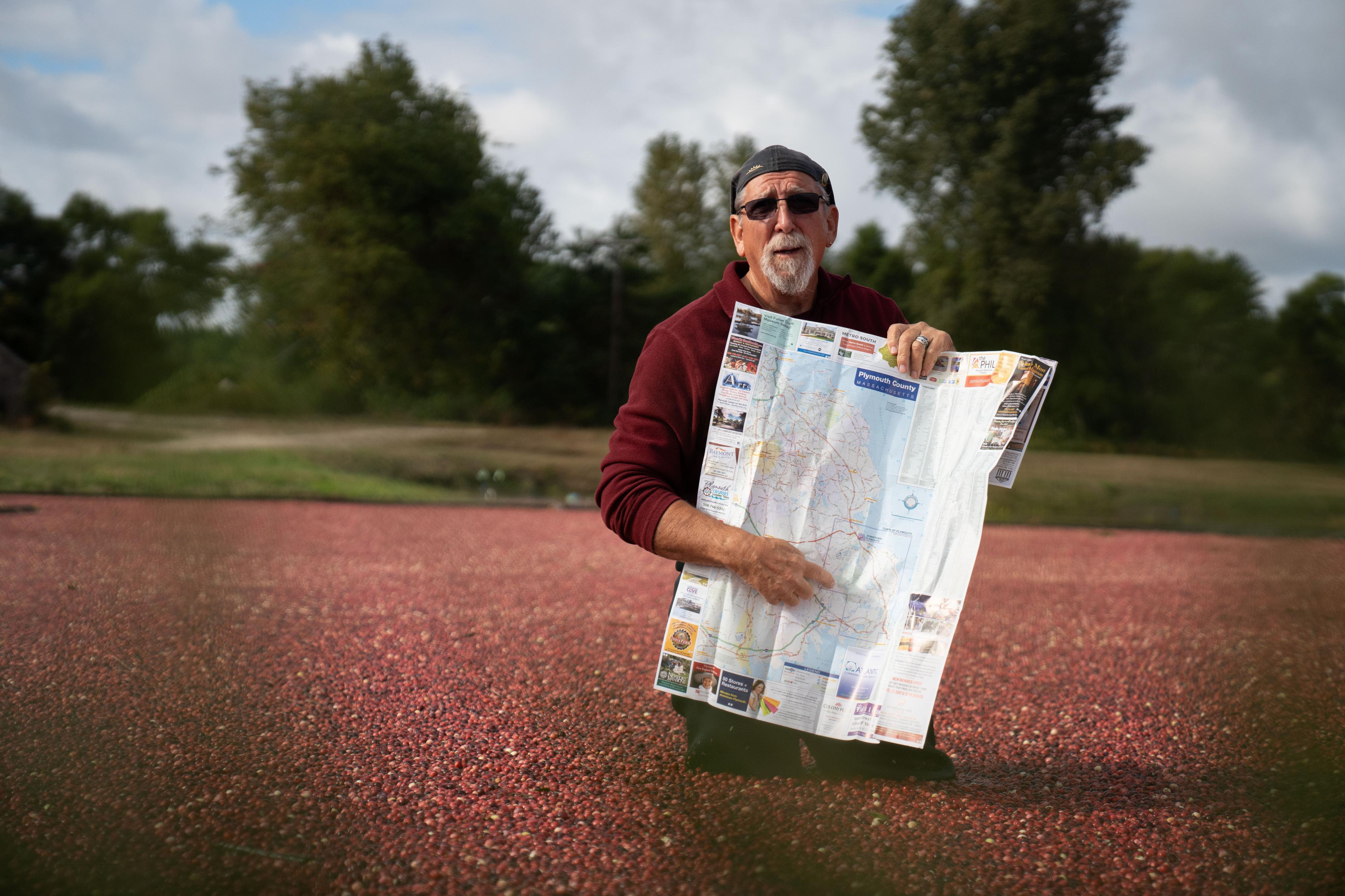man with a map standing in a field