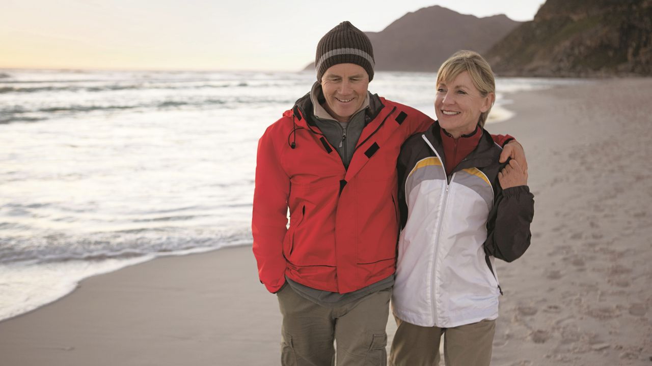 White straight mature couple walking on the beach