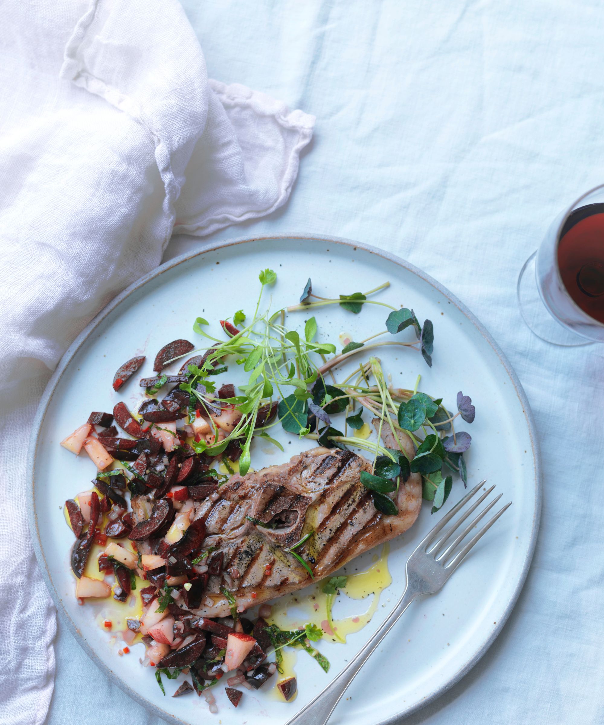 Plate of food with a piece of grilled fish and cherry and peach salsa