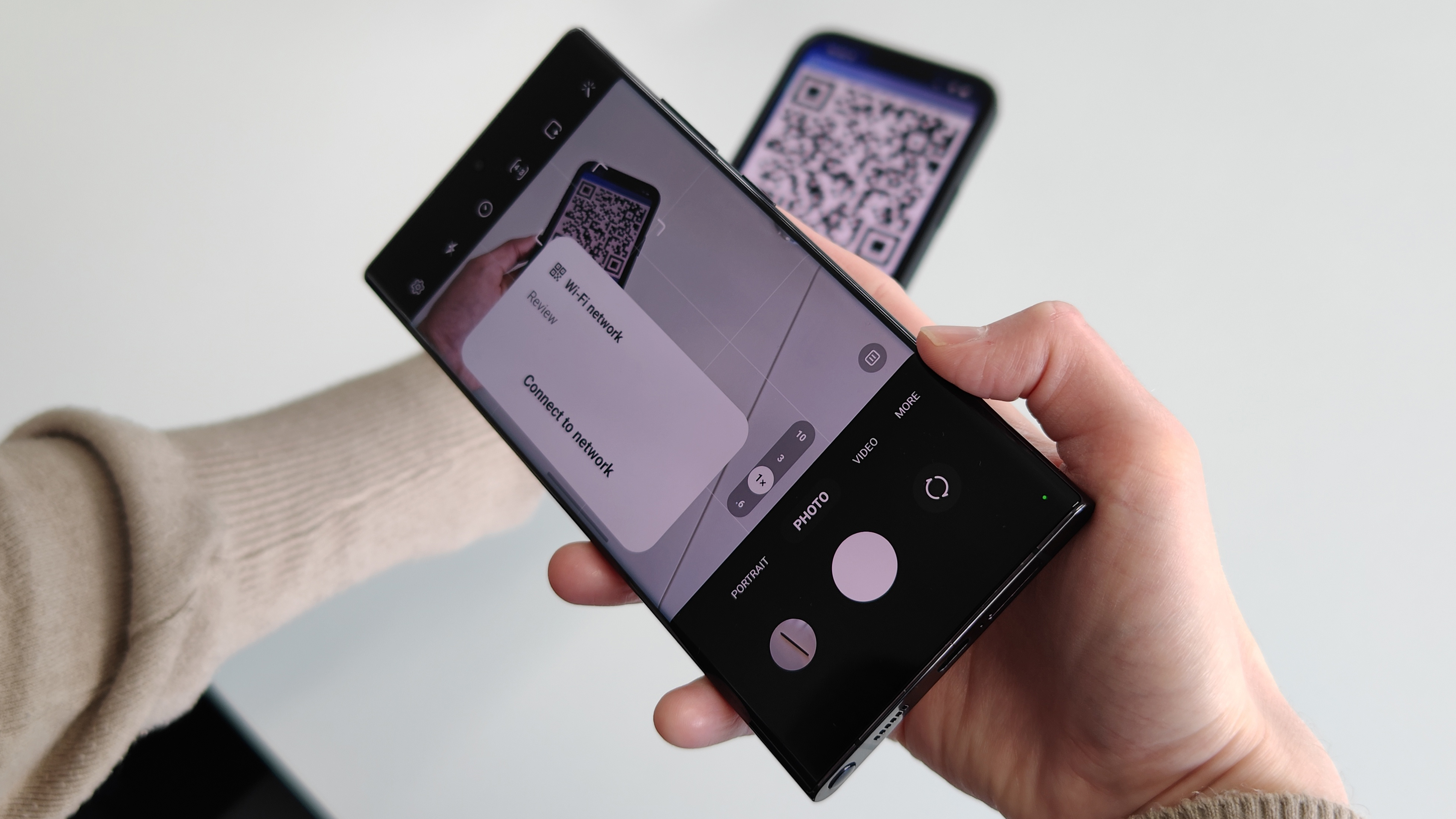 A Samsung Galaxy S22 Ultra scanning a Wi-Fi QR code from an iPhone 13 Pro Max