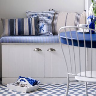 Grey painted bench with hidden storage and blue cushions on top