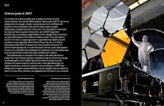 A NASA scientist stands next to a giant telescope mirror