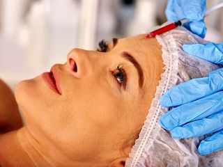 A woman undergoes a botox injection.