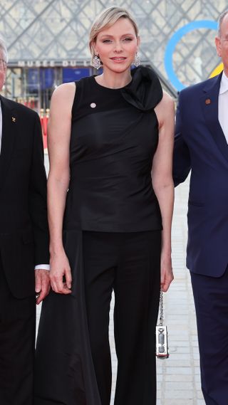 Princess Charlene of Monaco poses for a photo with Prince Albert and the IOC President Thomas Bach outside the Louvre