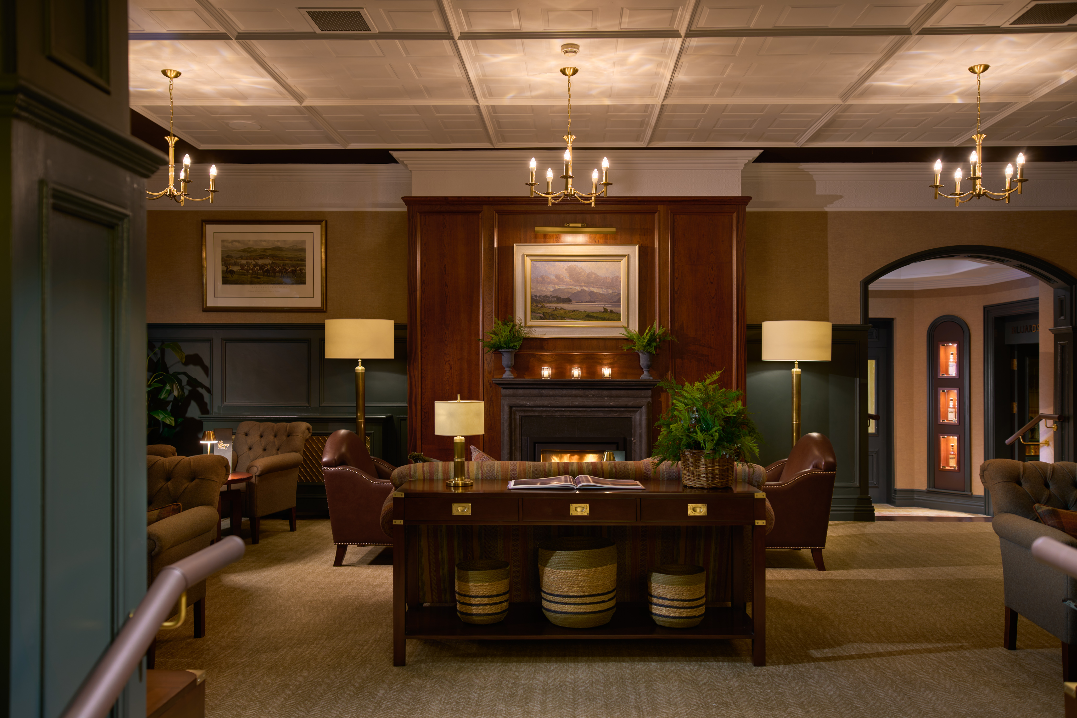The cozy lobby of Killarney Park hotel with a fireplace and leather chairs
