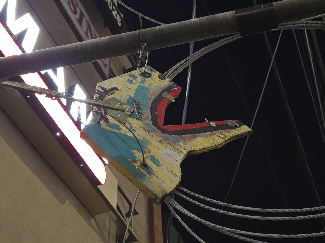 A wooden carving of an animal face hanging from a pole