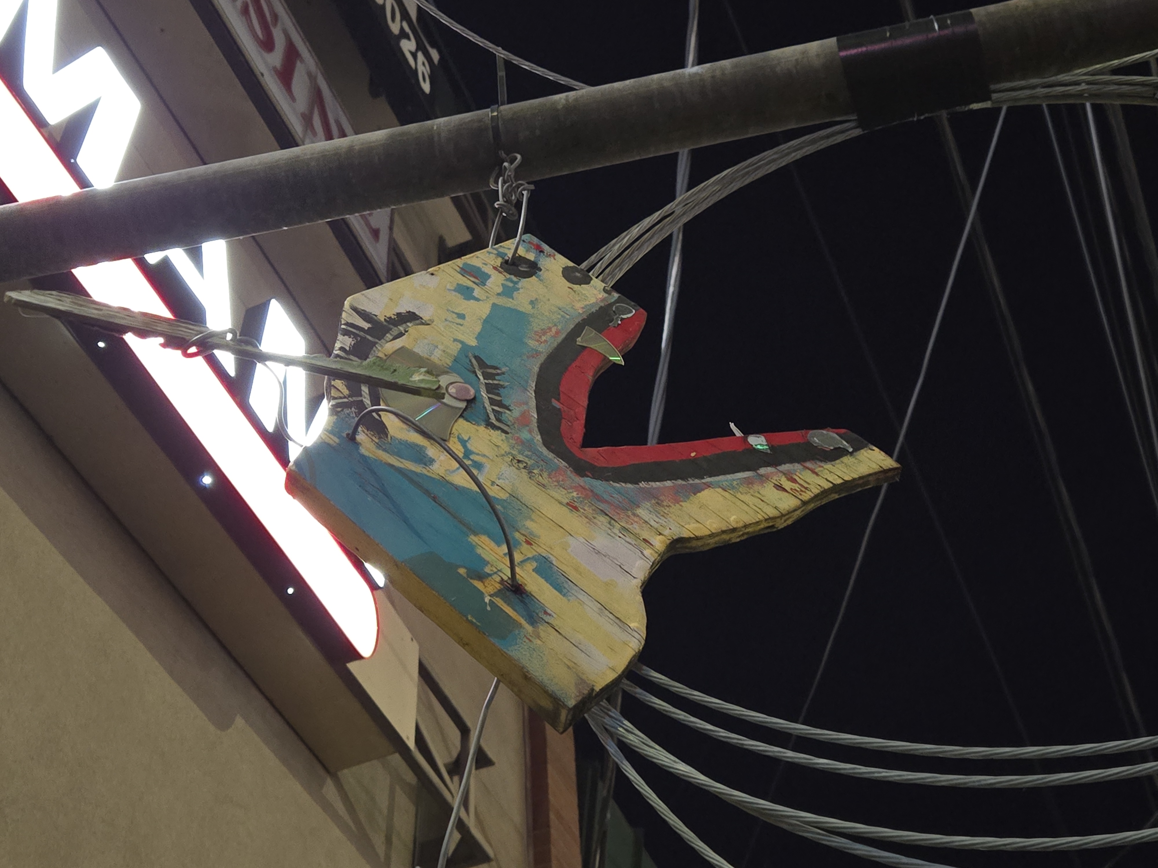A wooden carving of an animal face hanging from a pole