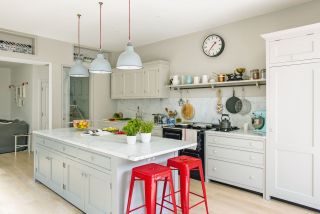 kitchen in extension with large island and red bar stools photographed by polly eltes