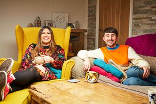 Pete and Sophie sitting on the sofa and smiling at the camera for Gogglebox
