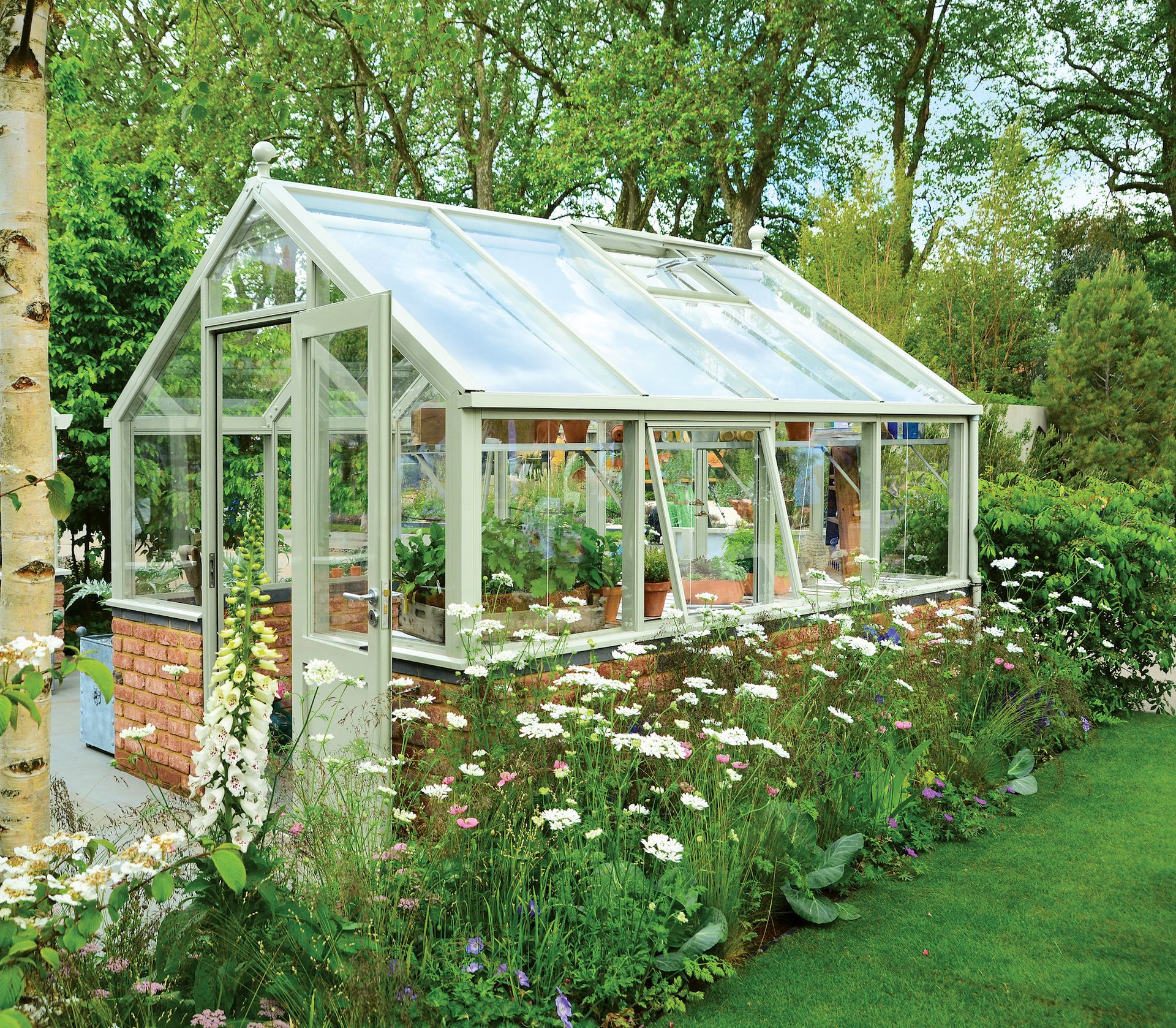 greenhouse in country garden with white flowers