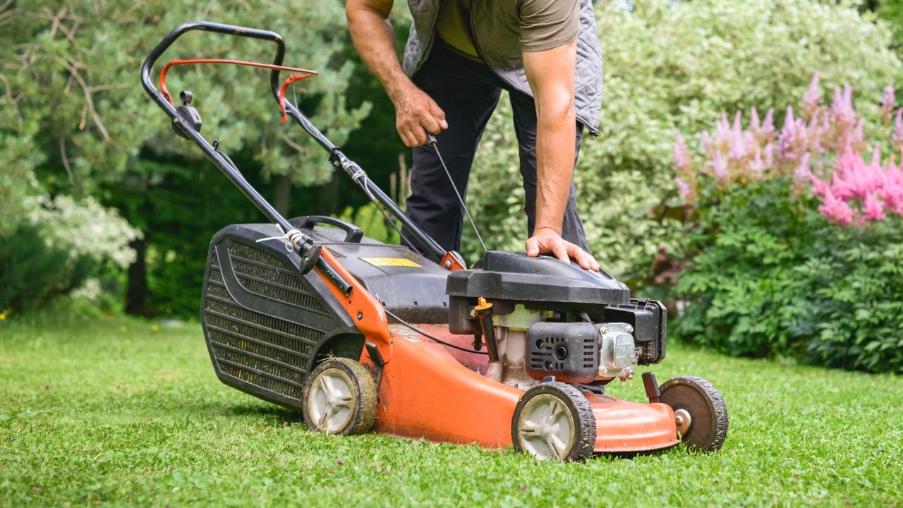 An example of what to do when your lawnmower pull cord is stuck, a man pulling a lawn mower cord