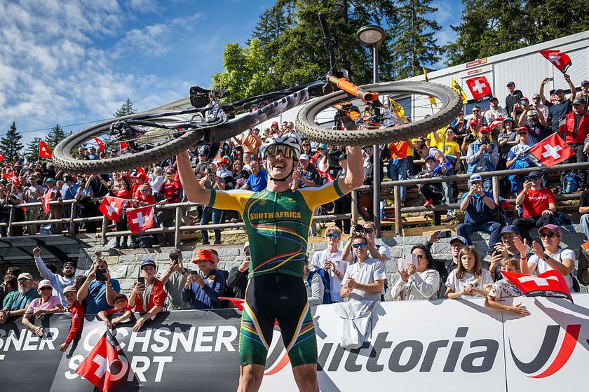 South Africa&#039;s Alan Hatherly holds up his bicycle to celebrate winning in the Men&#039;s elite Cross-country Olympic race as part of the 2025 UCI Mountain Bike World Championships in Crans-Montana on September 14, 2025.