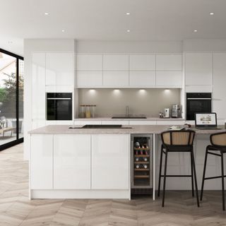 Clean white modern Benchmarx kitchen with large island, white cabinets, bi-fold doors to the left and wooden floors