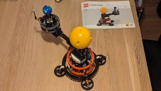 Lego technic planet earth and moon in orbit set on a white background