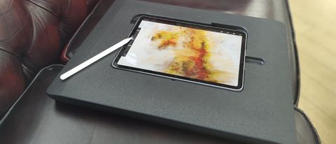 Darkboard for iPad; an iPad Pro inserted into a black iPad drawing stand on a leather sofa