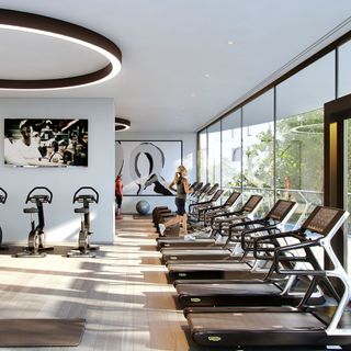 white gym area with treadmills on wooden flooring