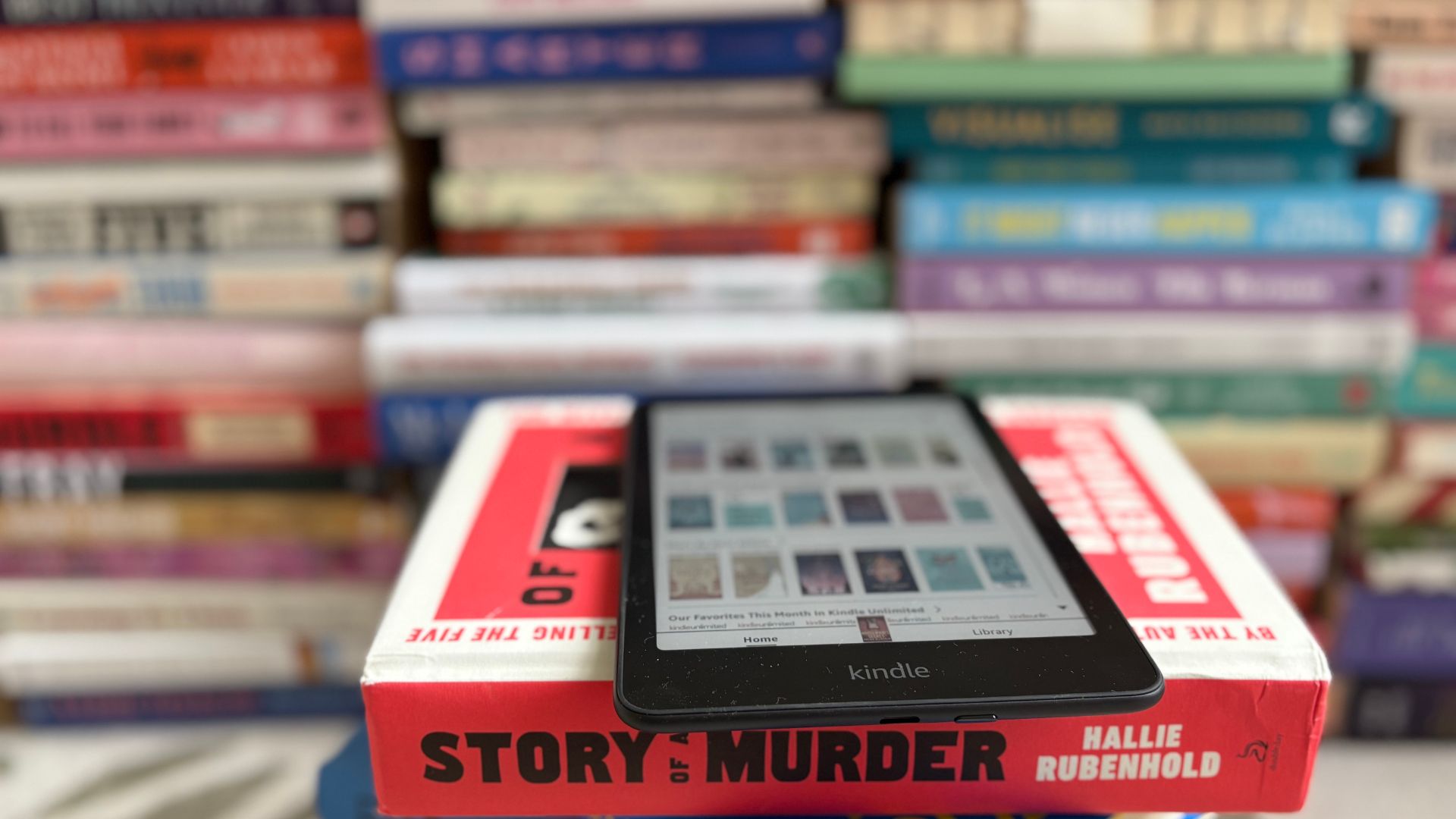 The Kindle Colorsoft with Kindle Unlimited open in front of books
