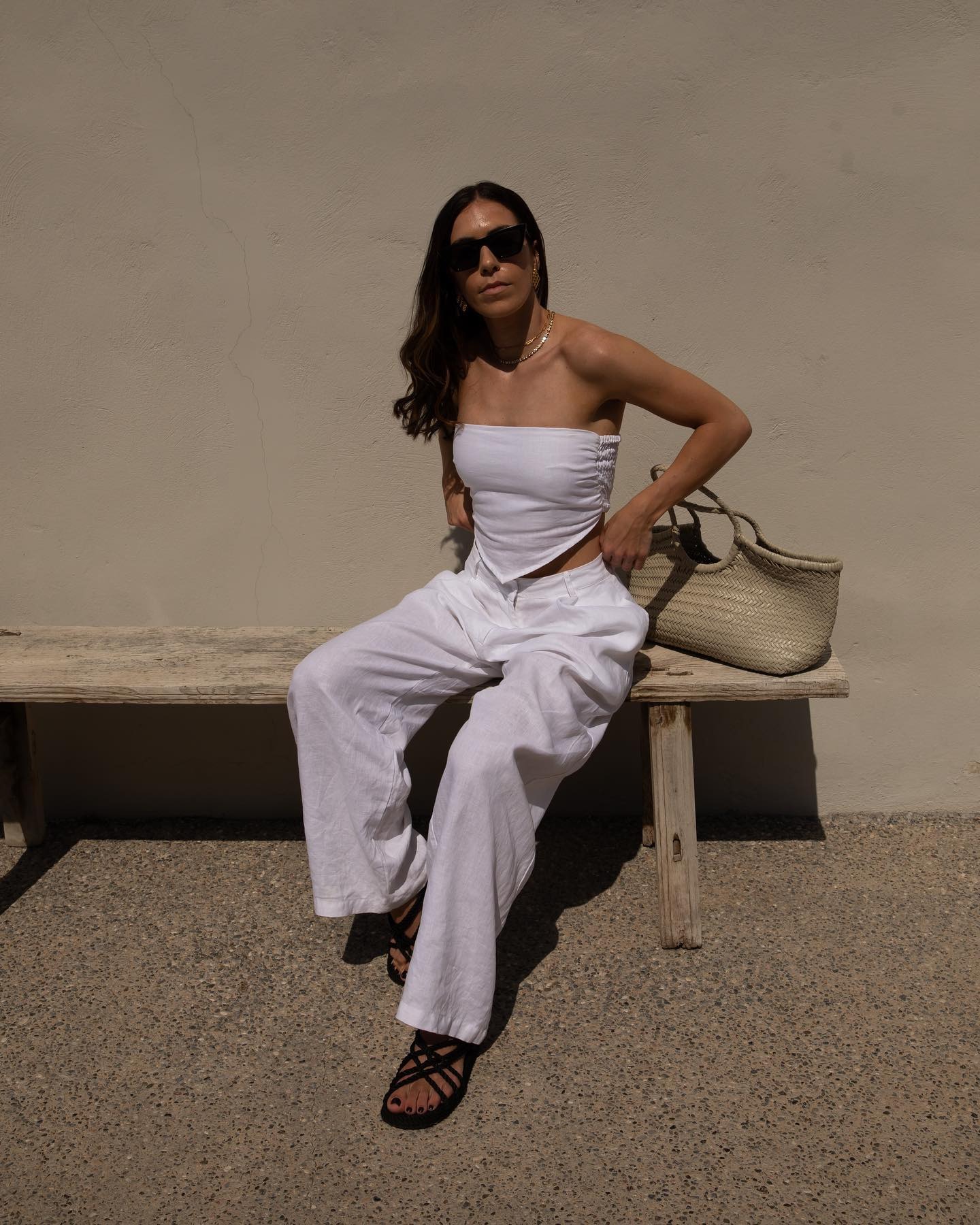 Influencer @_jessicaskye wears white jeans with a white sleeveless top.