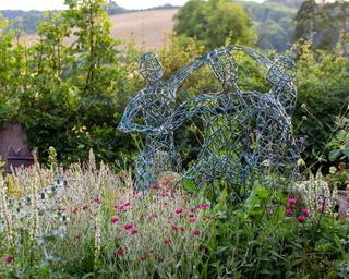 figurative metal sculpture in naturalistic garden