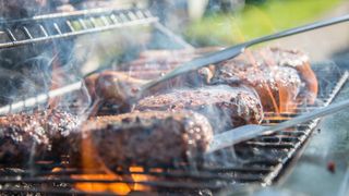 bbq grill with burgers being cooked