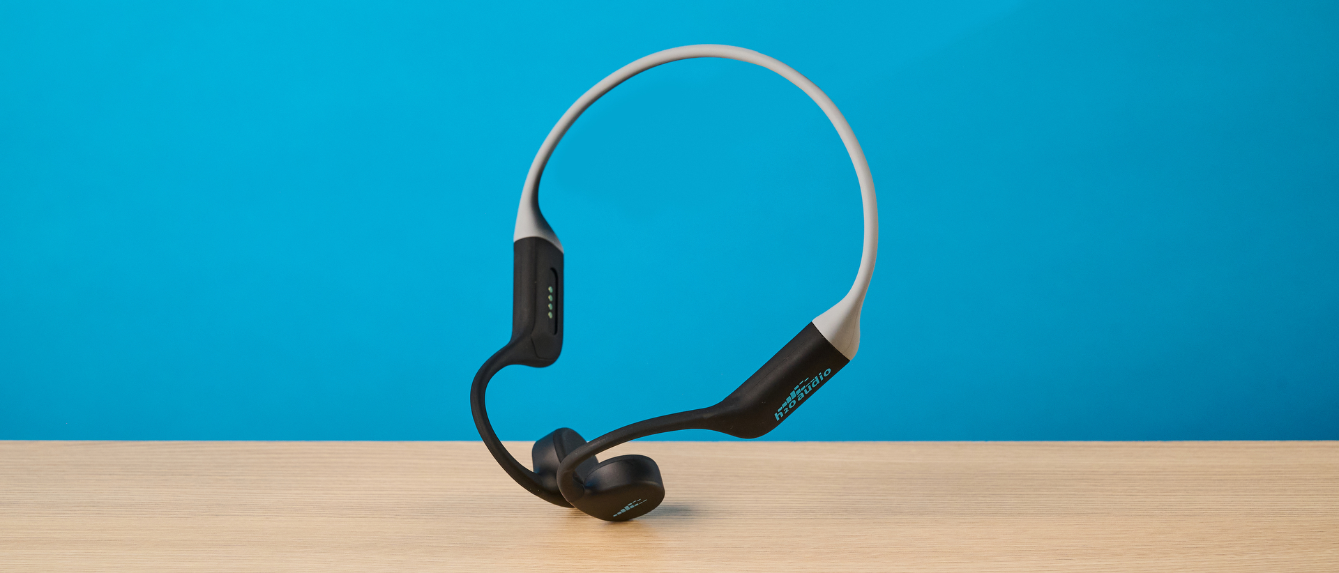 the h2o audio tri run bone conduction headphones photographed against a tom's guide blue background