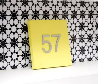 yellow house number plaque