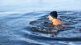 Man swimming in icy water