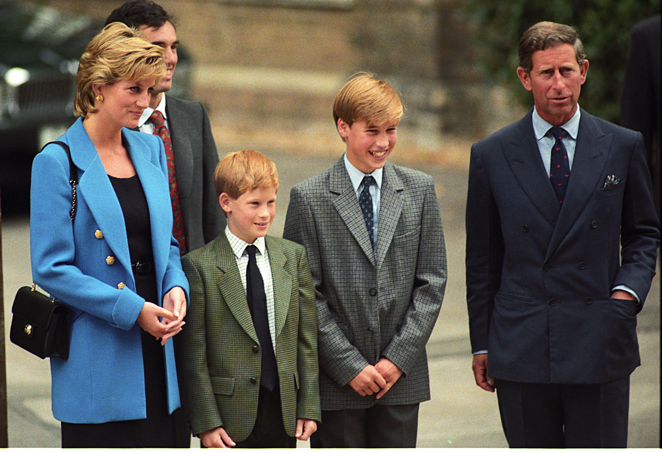 Princess Diana, Prince Harry, Prince William and Prince Charles wearing suits standing in a row at Eton College in 1995