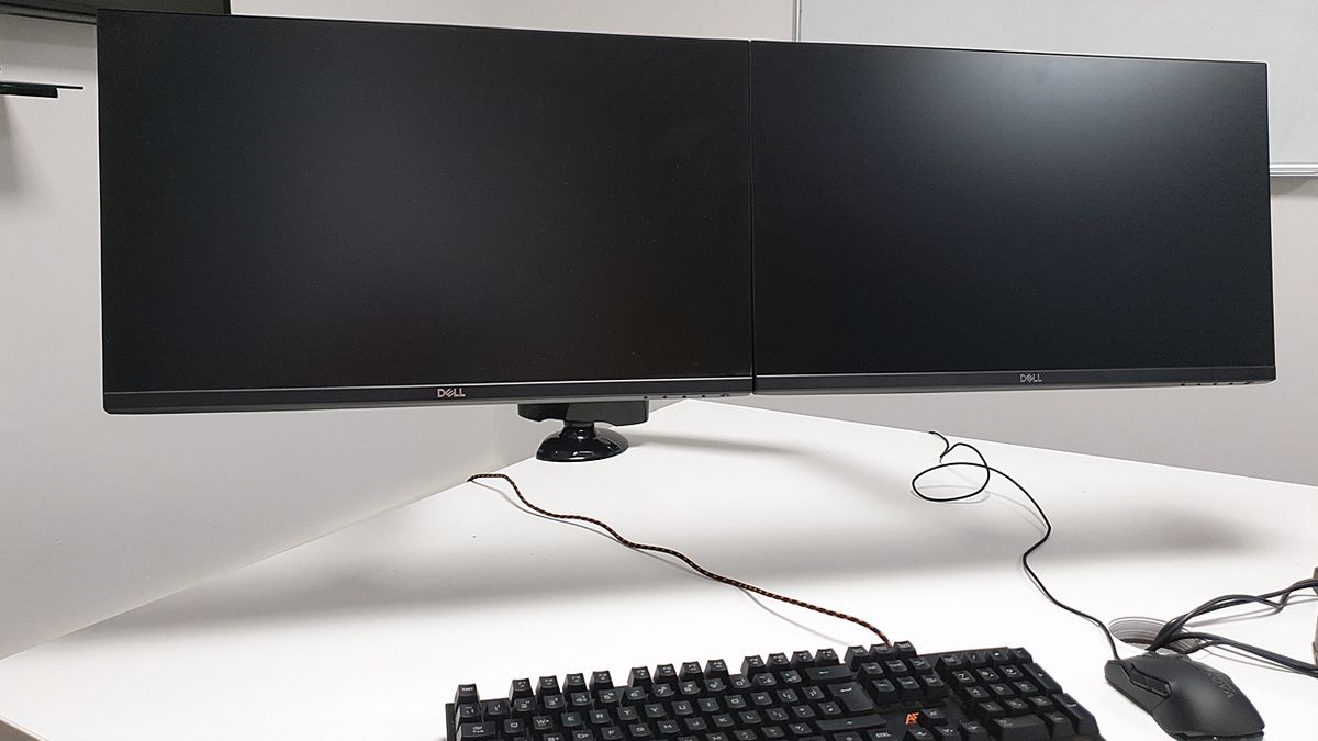 The completed set up shows how much desk space is saved and also the posture-benefiting height that the monitors can be moved to.