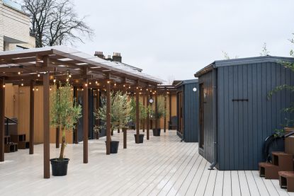 Lowlu Sauna, a Kentish town sauna, showing the outdoors area which is a timber structure with a deck, canopy and sauna cabins
