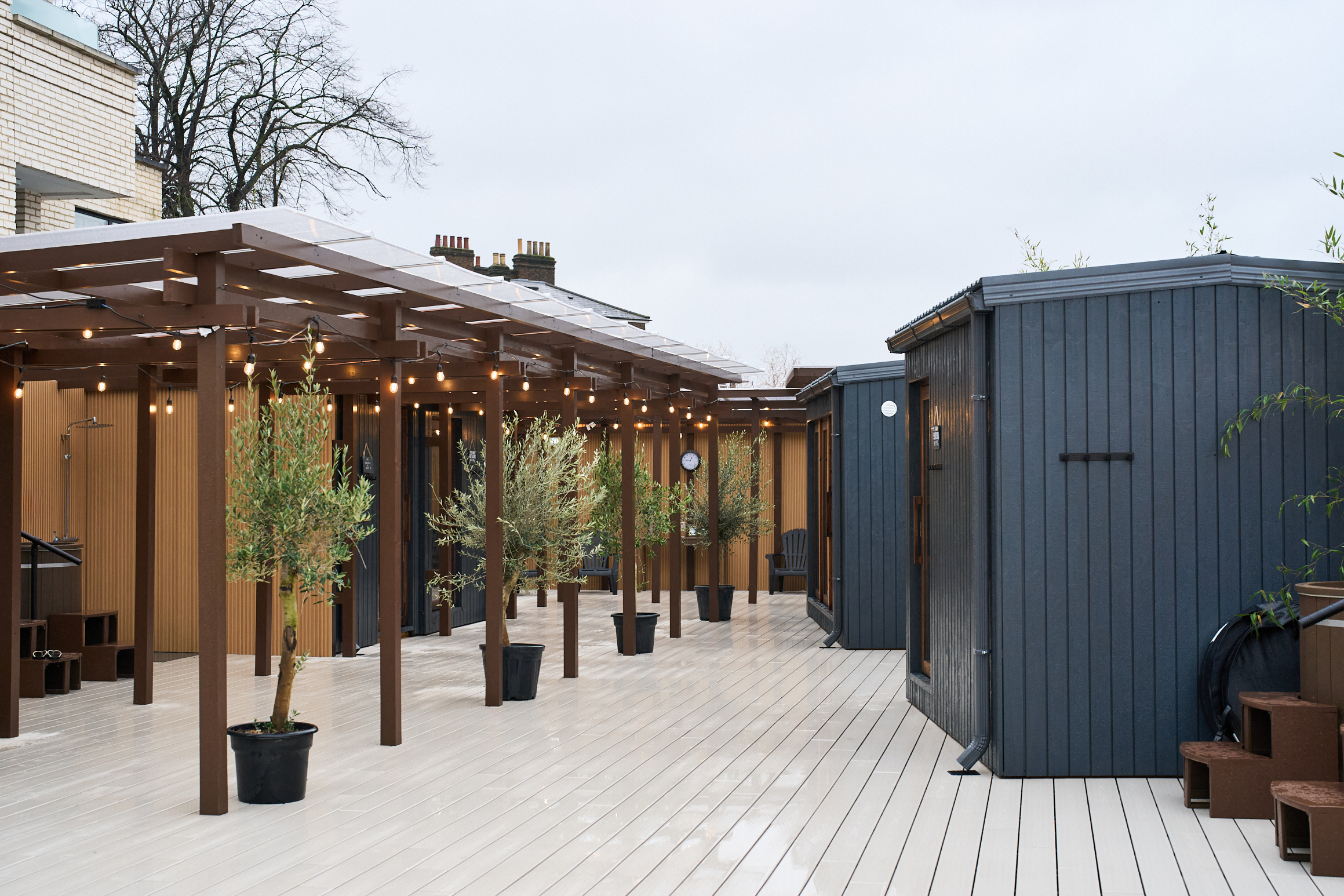 Lowlu Sauna, a Kentish town sauna, showing the outdoors area which is a timber structure with a deck, canopy and sauna cabins
