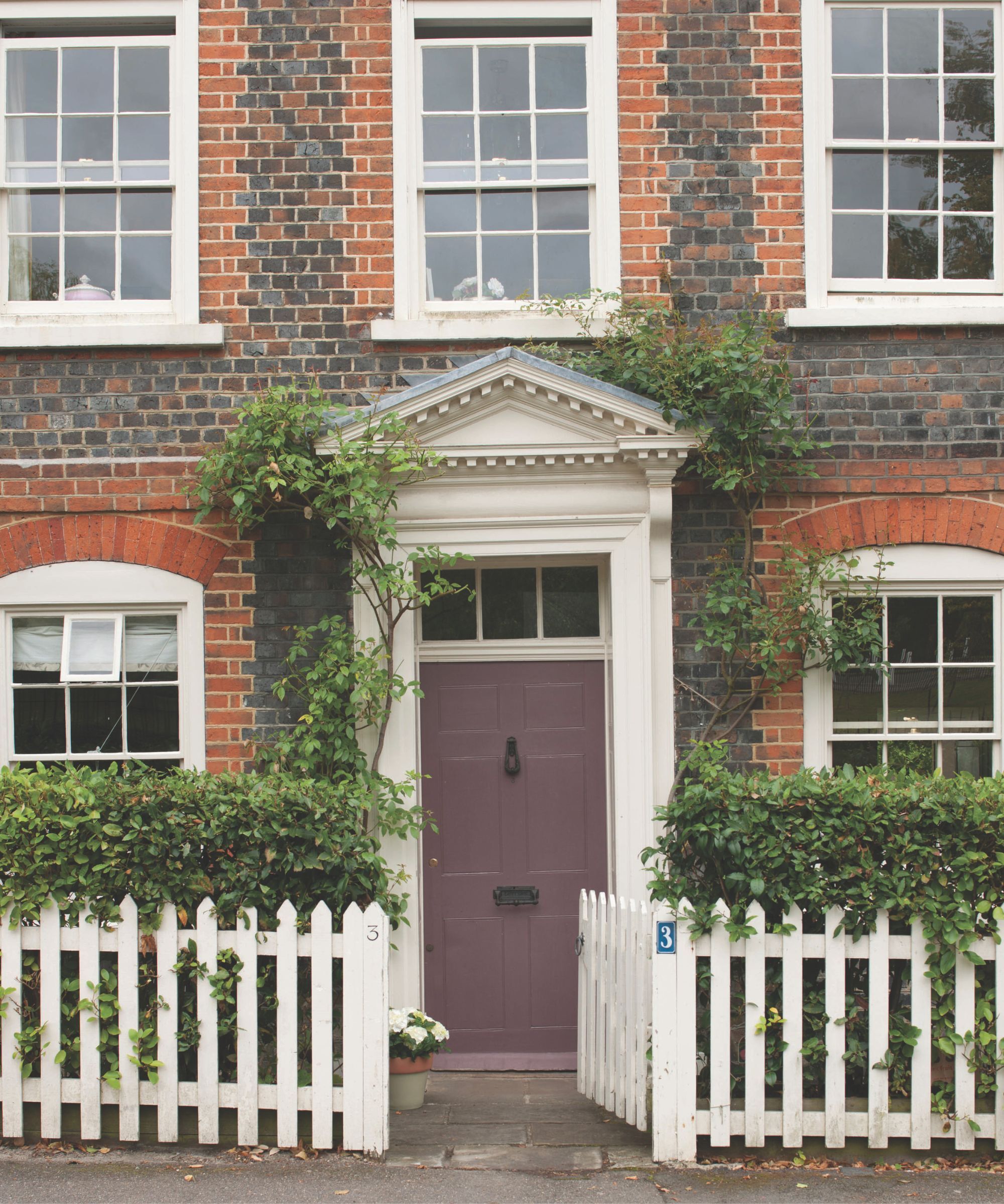 A red brick house with a purple front door