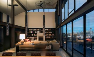 living room with high ceilings and full length glass windows showing a view of dowtown Seattle