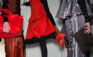 Models wear Red, intricate jacquards, embroideries, sequin bedazzled knitwear.