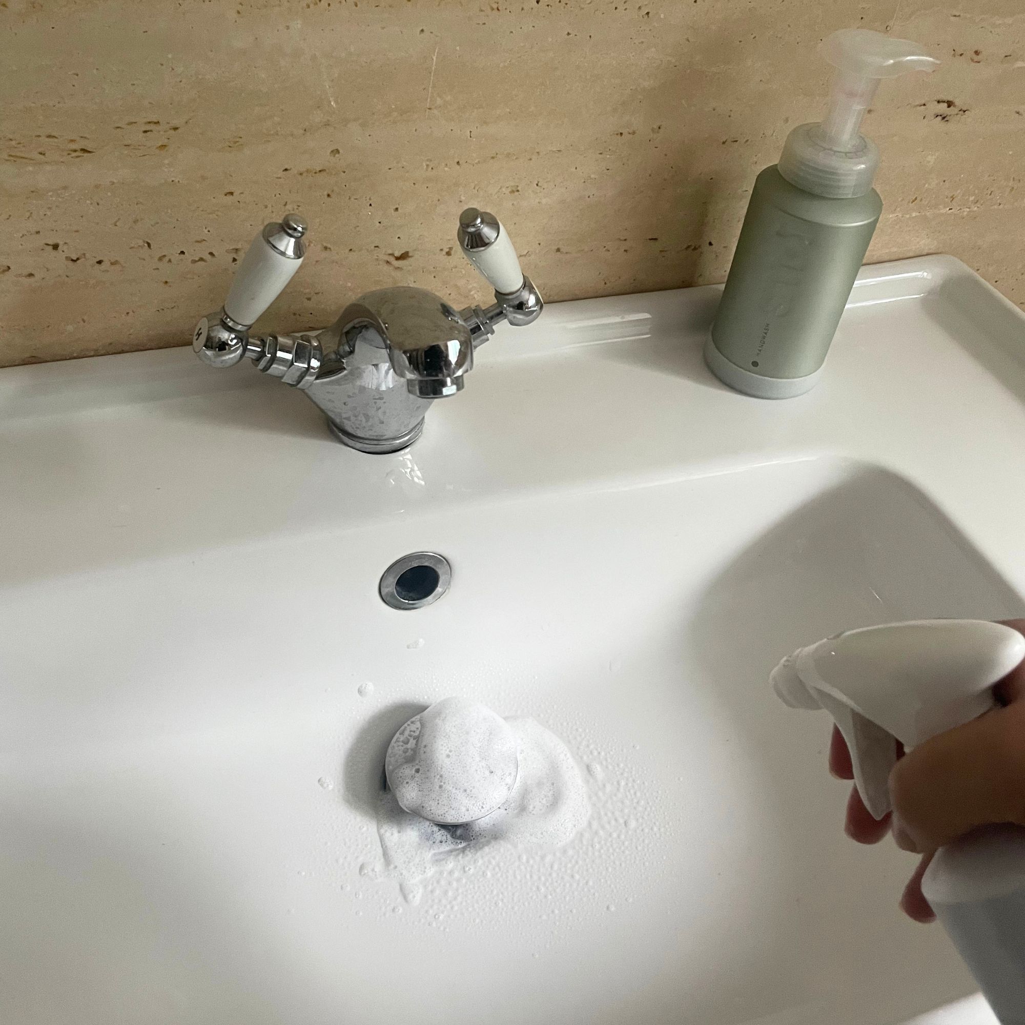 Cleaning a white sink with smol bathroom cleaner