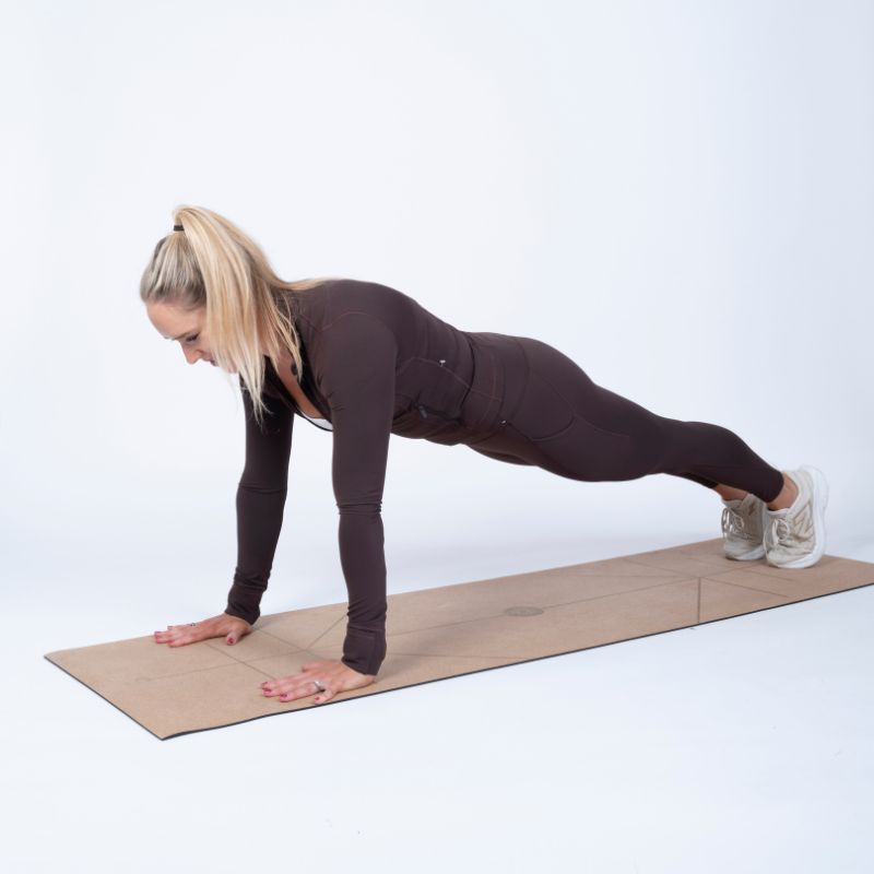 Sarah Campus demonstrating how to do a push up in the starting position on a yoga mat