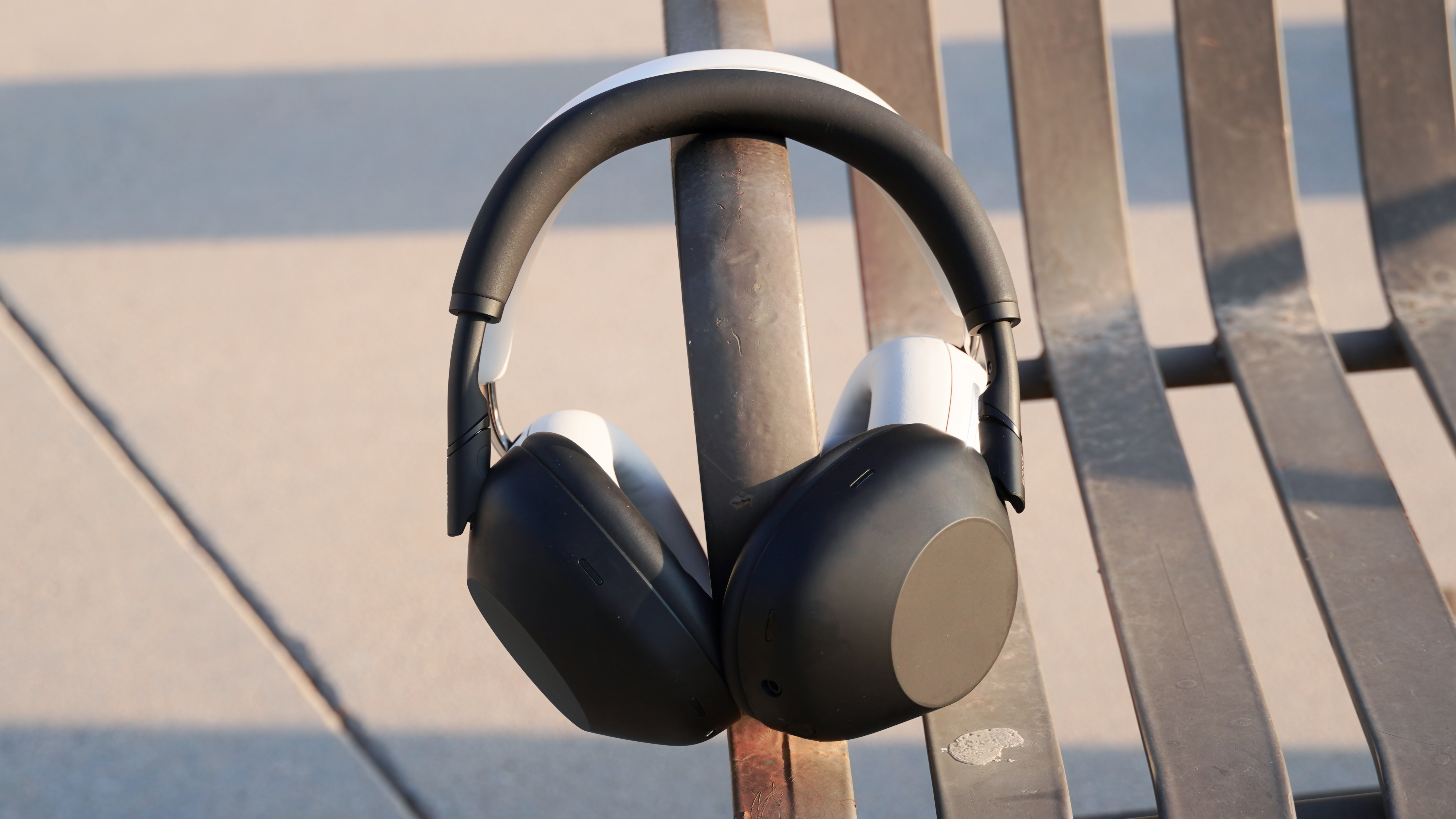 The Sony WH-1000XM6 in front of the Sonos Ace on a park bench.