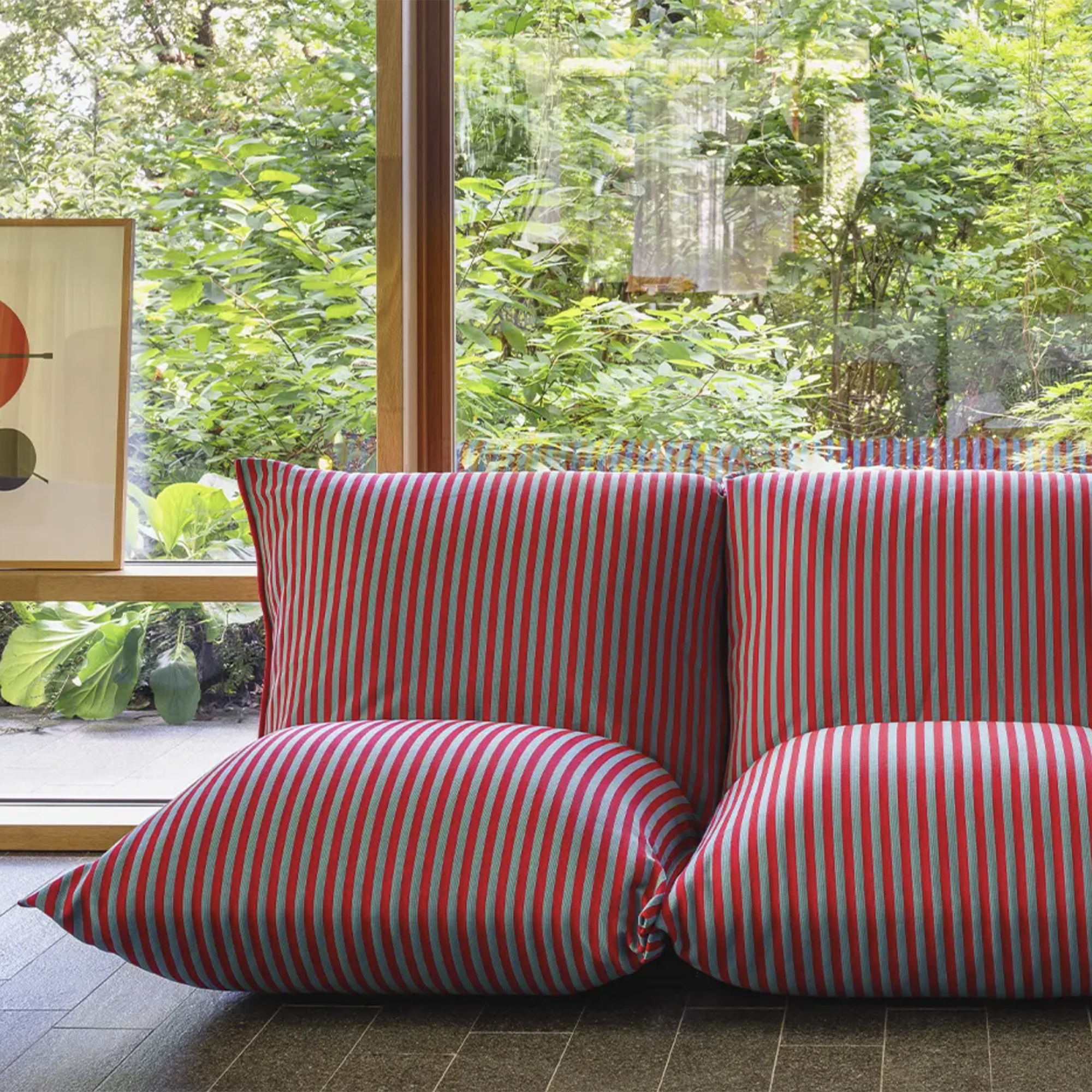 red striped sofa in front of a big window