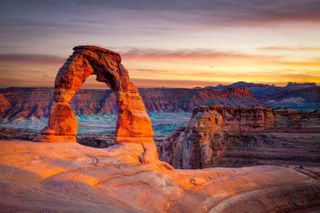 Delicate Arch at Arches National Park in Utah with the sun shining on it