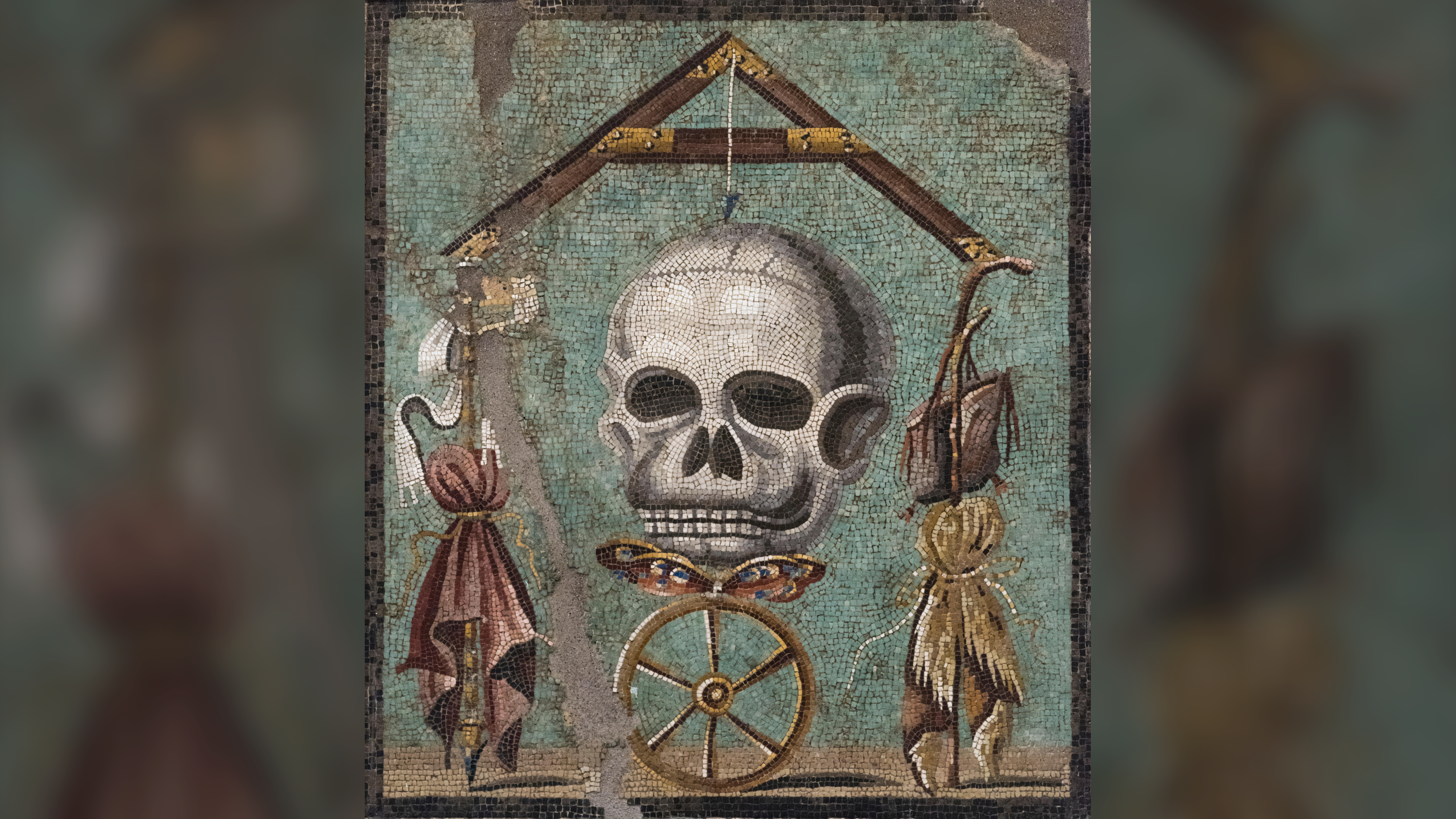 mosaic of a skull surrounded by other items on a teal green background