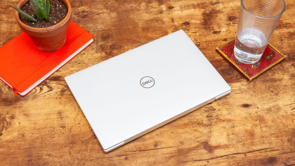 Dell XPS 13 (2020) on a wooden coffee table with a glass of water