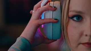 Promotional screenshot of a woman putting on the Logitech G Astro A20 X Gaming Headset