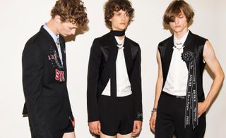 three male models wearing white shirts and black blazers designed by Christian Dior
