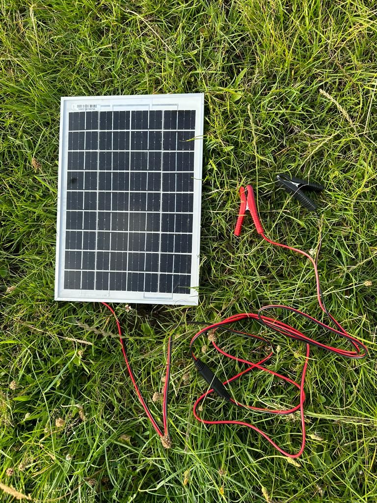 The solar panel charger on the grass with clips