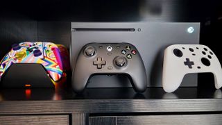 GameSir G7 Wired Controller propped against Xbox Series X with white faceplate and Xbox Wireless Controller to the side.