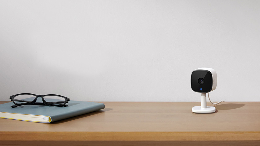 Eufy Indoor Security Camera on a side board next to a book and some glasses