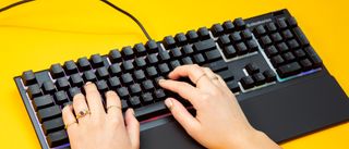 Person typing with two hands on an RGB-enabled gaming keyboard