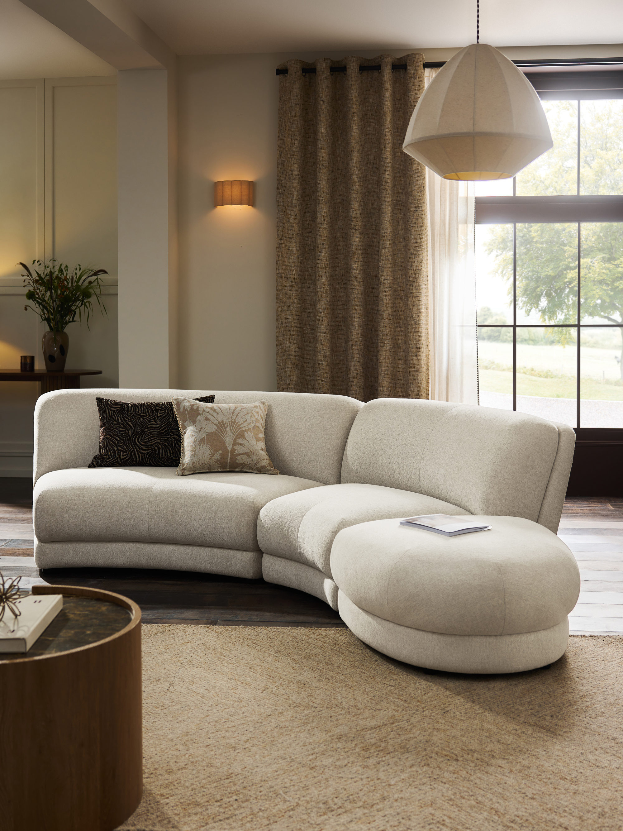 Next Addison Modular Sofa with jute rug, cushions, patterned curtains, round timber coffee table