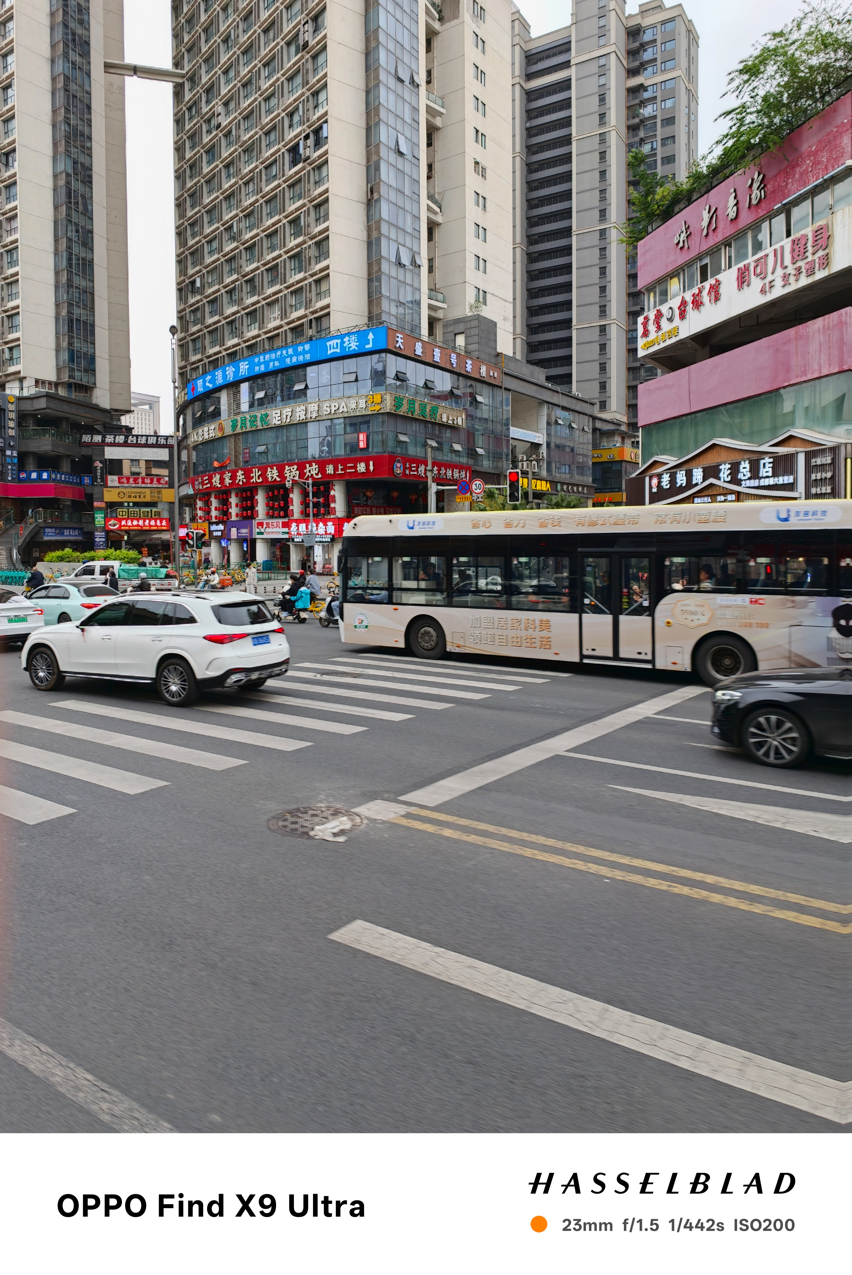 Urban street scene with bus, crosswalk, and Chinese storefront signs