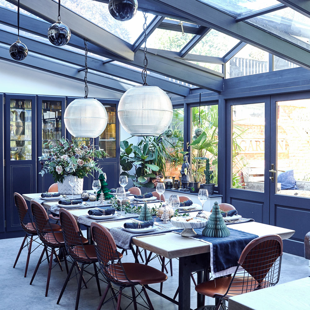 Open-plan kitchen dining area with glass roof and hanging pendant lights